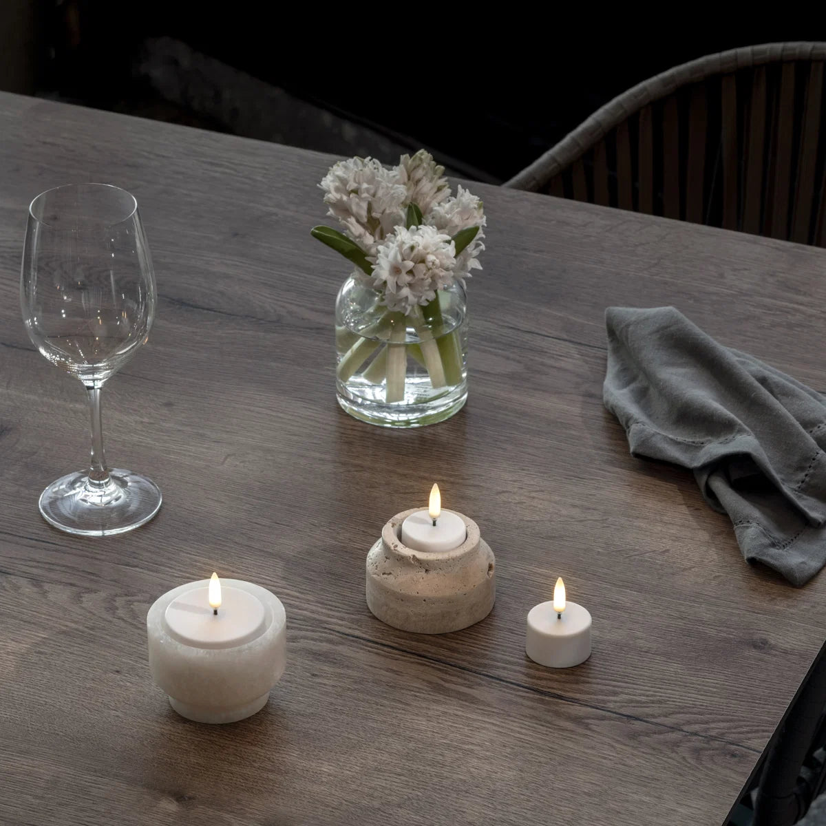 UYUNI uppladdningsbara LED-värmeljus i olika storlekar på dukat bord