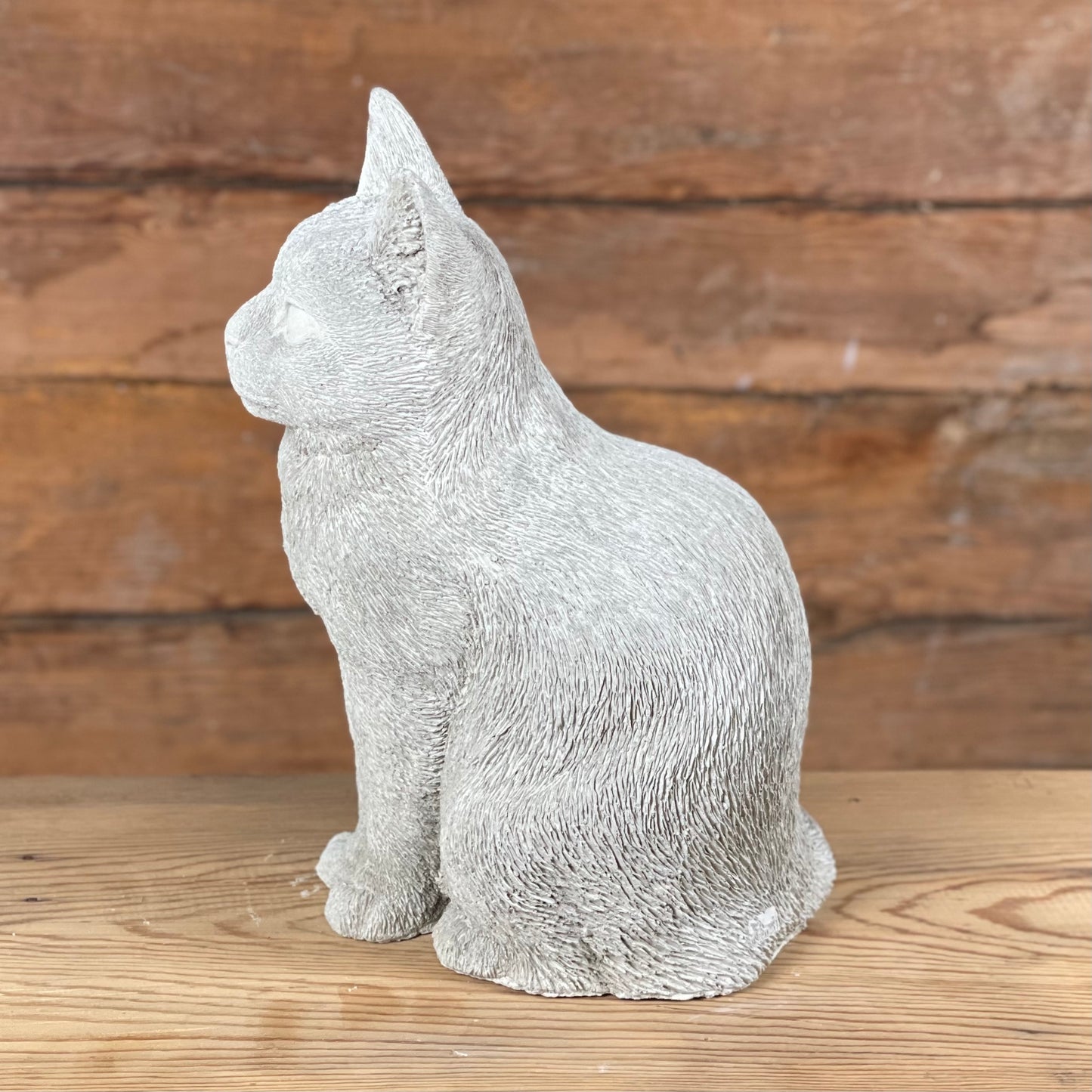 Katten Trisse – handgjuten betongkatt sedd från sidan med detaljrik pälsstruktur.