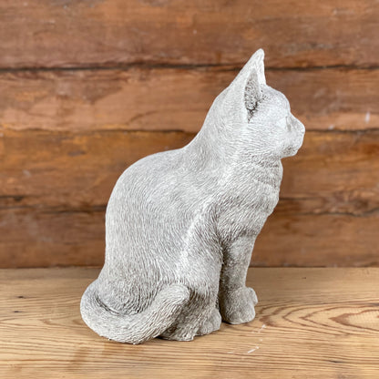 Katten Trisse – naturtrogen betongkatt sedd från sidan med böjd svans och mjuka former.