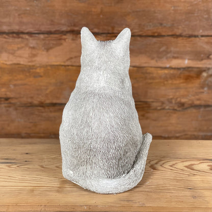 Katten Trisse – betongkatt sedd bakifrån med detaljerad svans och pälsstruktur.