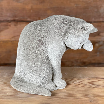 Helbild av betongfiguren Selma, sittande katt i naturtrogen pose