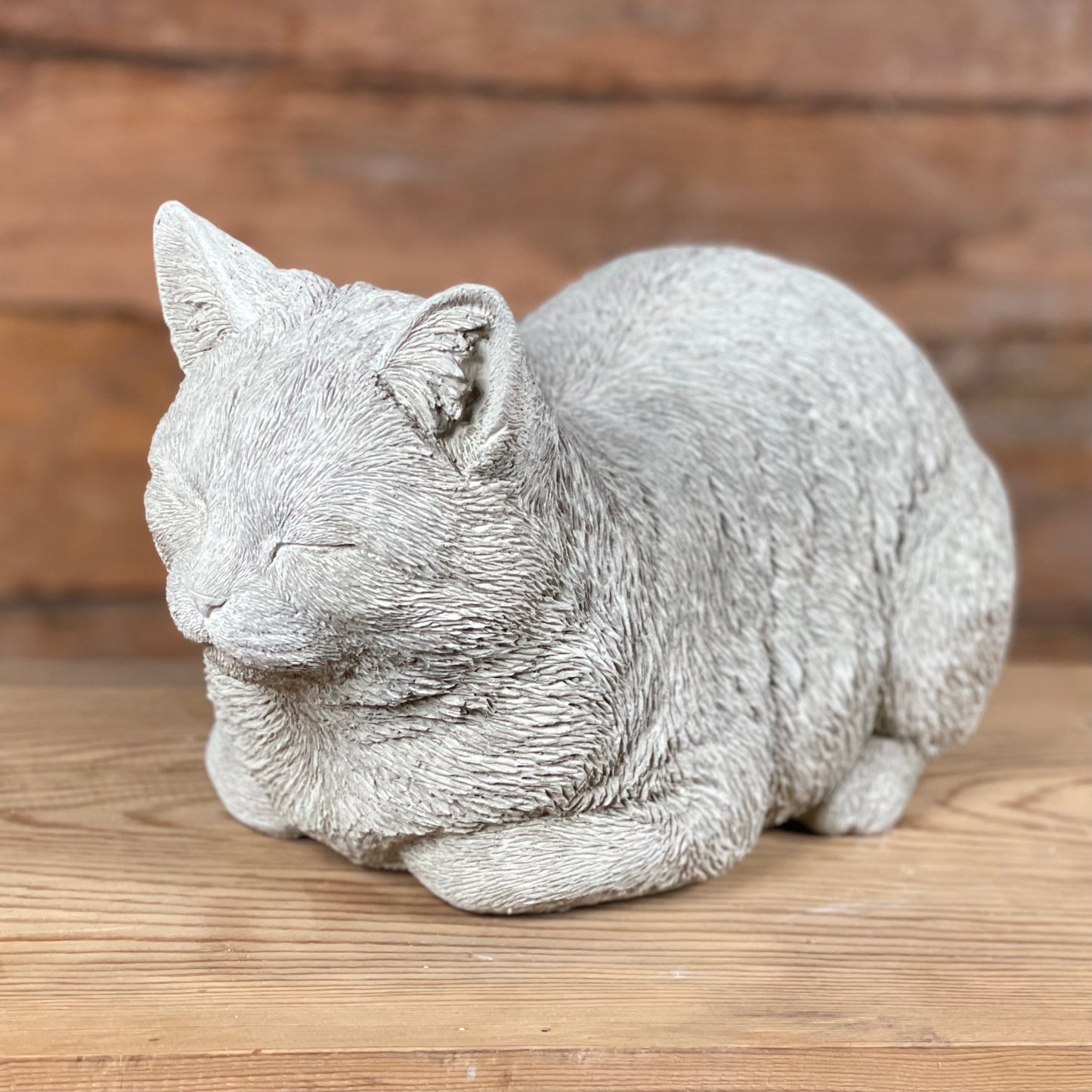 Sovande katt i betong – Katten Måns, naturtrogen trädgårdsfigur sedd från sidan.