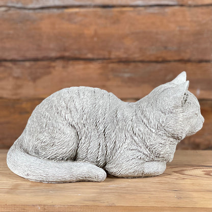 Betongfigur av liggande katt – Katten Måns, visad från sidan med markerad svans och pälsstruktur.