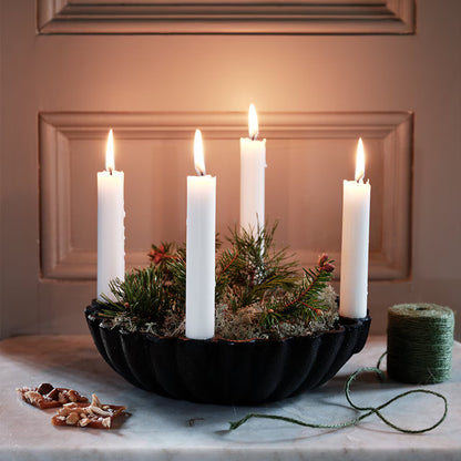 Svart ljusstake med skål dekorerad med mossa och fyra kronljus