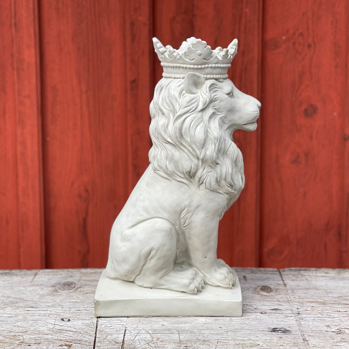 Sittande betonglejon med krona från sidan