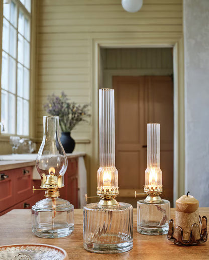 Fotogenlampa Elvira i klart glas på dukat bord